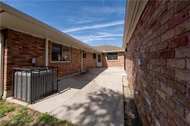 view of side of property with a patio and central AC