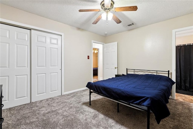 carpeted bedroom featuring ceiling fan, a textured ceiling, and a closet