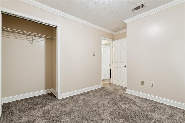 unfurnished bedroom featuring ornamental molding, carpet, a textured ceiling, and a closet