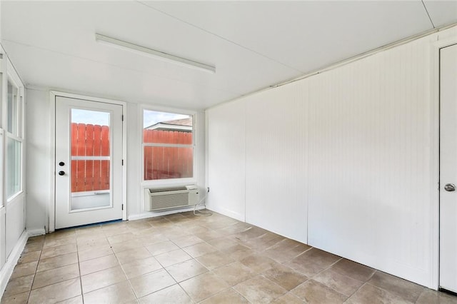 empty room featuring a wall mounted AC and tile patterned floors