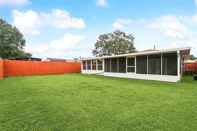 back of house featuring a lawn and a sunroom