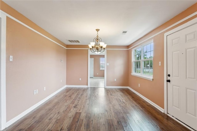 unfurnished dining area featuring a notable chandelier and hardwood / wood-style floors