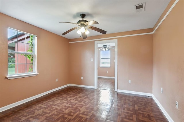 unfurnished room with dark parquet flooring and ceiling fan