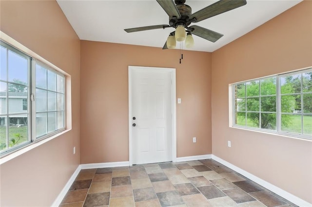 empty room featuring ceiling fan and plenty of natural light