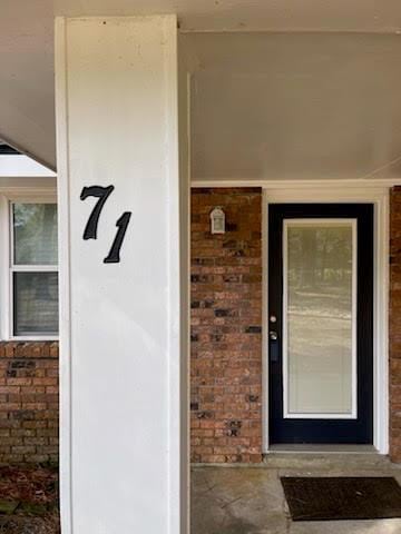 property entrance featuring brick siding