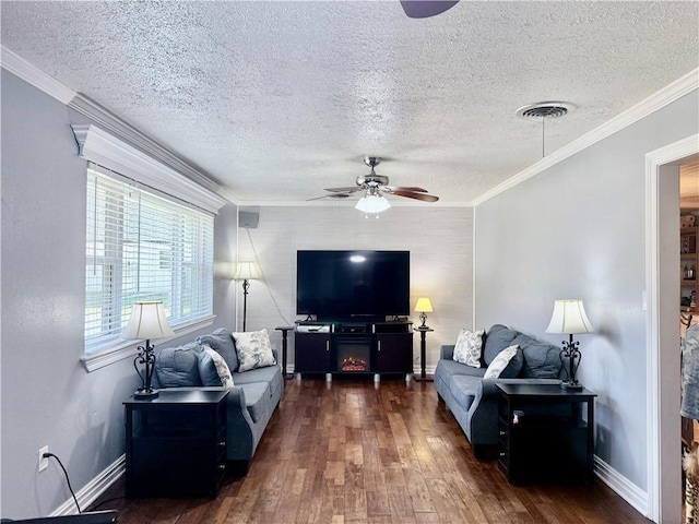 living area with wood finished floors, a ceiling fan, crown molding, baseboards, and a textured ceiling