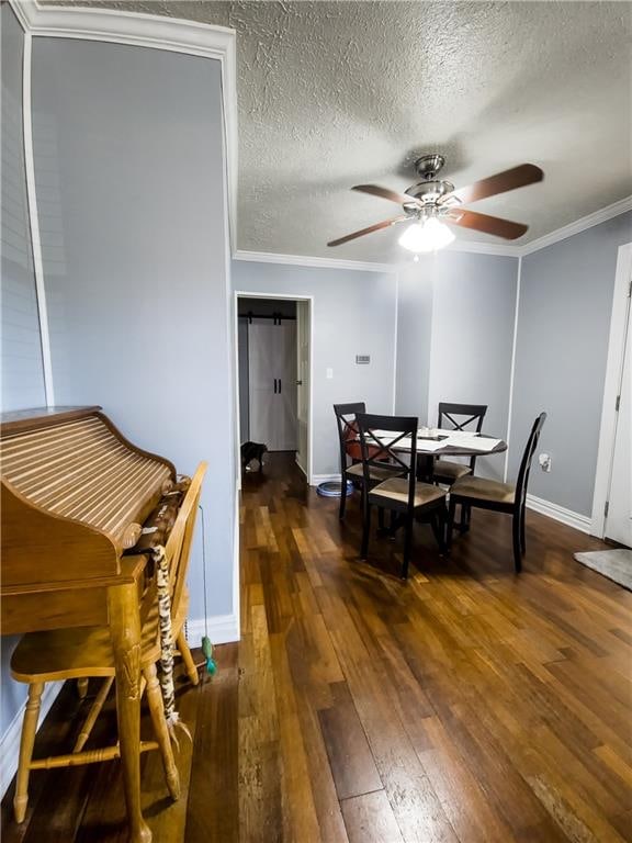 dining room featuring ornamental molding, a textured ceiling, dark wood-type flooring, and ceiling fan