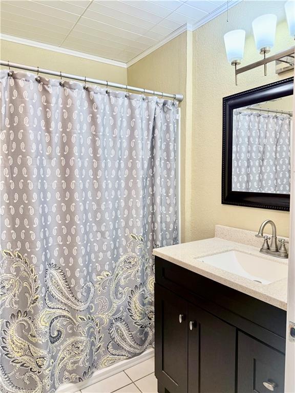 bathroom featuring curtained shower, tile patterned floors, vanity, and ornamental molding