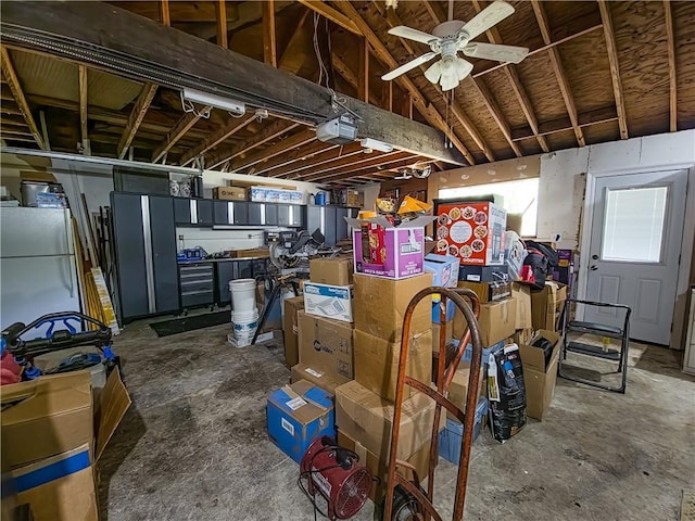 unfinished below grade area with freestanding refrigerator and ceiling fan
