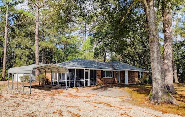 view of front of property with a sunroom and a carport