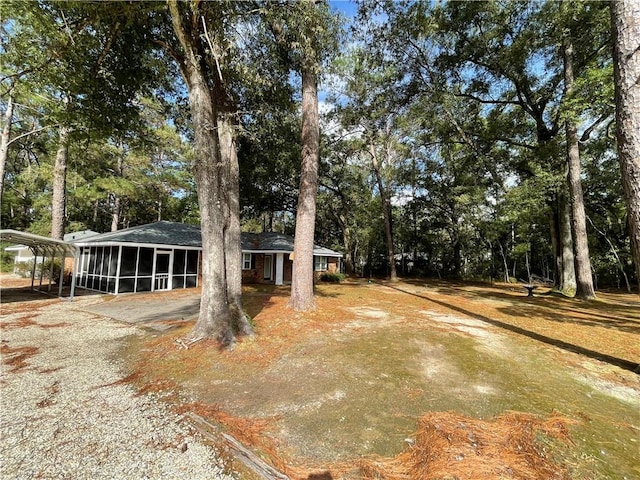 view of front of house featuring a sunroom, a carport, and driveway