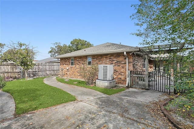 view of home's exterior featuring a pergola, a patio area, and a lawn