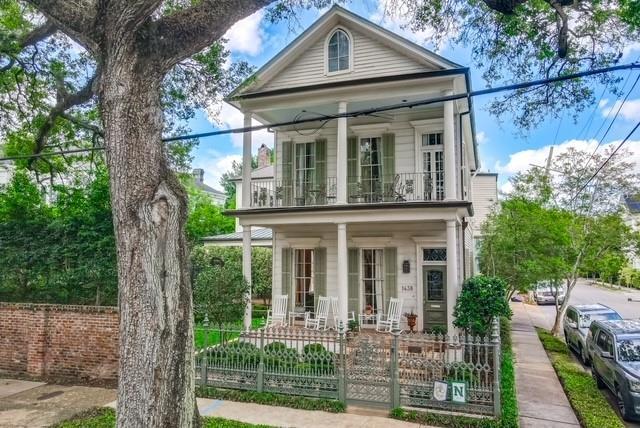 neoclassical home featuring a balcony and a porch