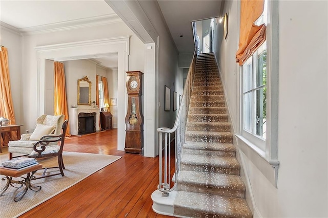 stairway featuring crown molding and wood-type flooring