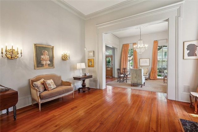 sitting room featuring wood-type flooring, ornamental molding, and a chandelier