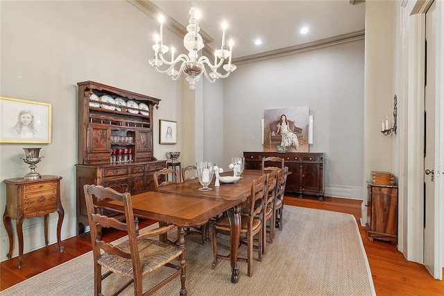 dining room featuring crown molding, an inviting chandelier, and hardwood / wood-style floors