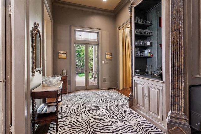 entryway with ornamental molding and light hardwood / wood-style flooring