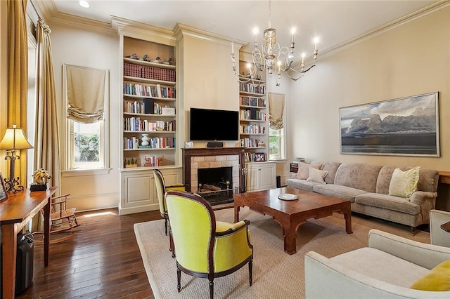 living room featuring a notable chandelier, crown molding, dark wood-type flooring, and built in shelves