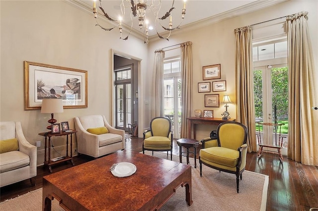 living area featuring crown molding, a notable chandelier, dark hardwood / wood-style flooring, and french doors