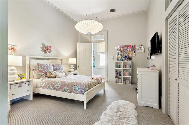 bedroom with crown molding, a closet, and carpet