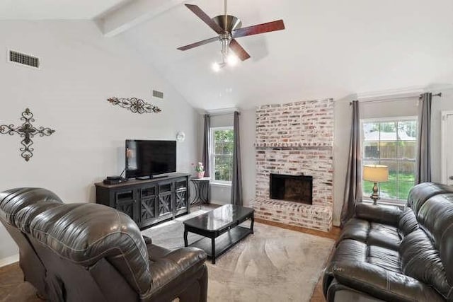 living room featuring ceiling fan, beam ceiling, a healthy amount of sunlight, and a fireplace