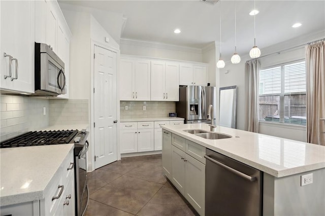 kitchen featuring hanging light fixtures, an island with sink, white cabinetry, sink, and stainless steel appliances