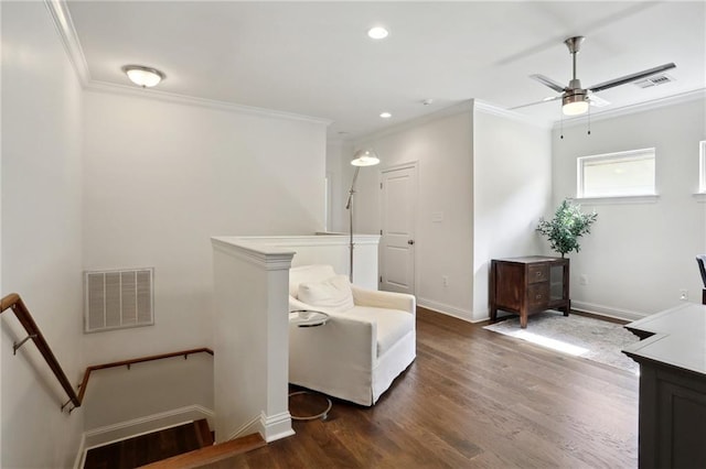 living area with ornamental molding, dark hardwood / wood-style floors, and ceiling fan