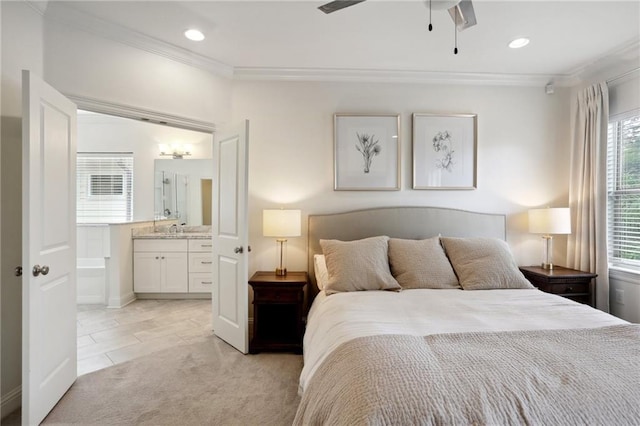 bedroom with ensuite bath, ornamental molding, sink, light colored carpet, and ceiling fan