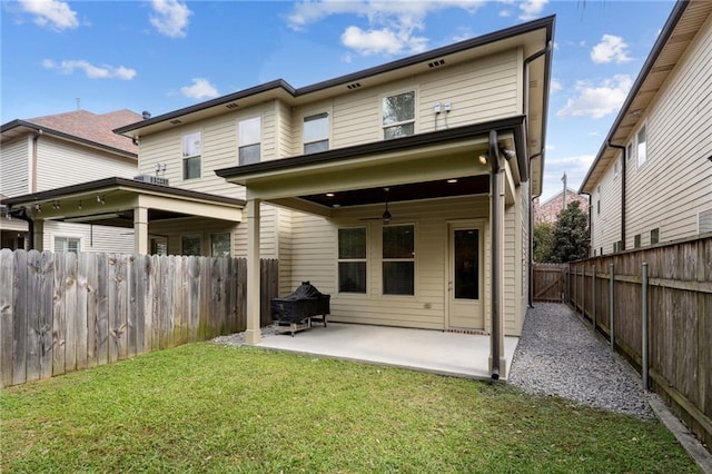 rear view of property featuring a patio, a lawn, and ceiling fan