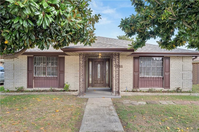 view of exterior entry with a yard