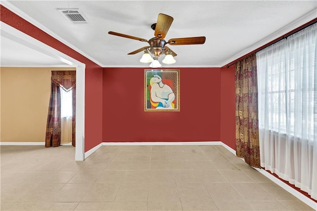 spare room with ceiling fan, ornamental molding, a wealth of natural light, and light tile patterned floors