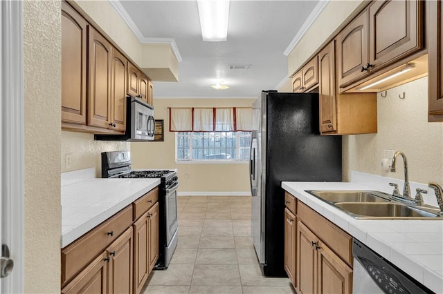 kitchen with light tile patterned flooring, ornamental molding, stainless steel appliances, and sink