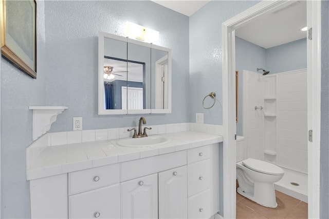 bathroom with vanity, a shower, toilet, and tile patterned floors