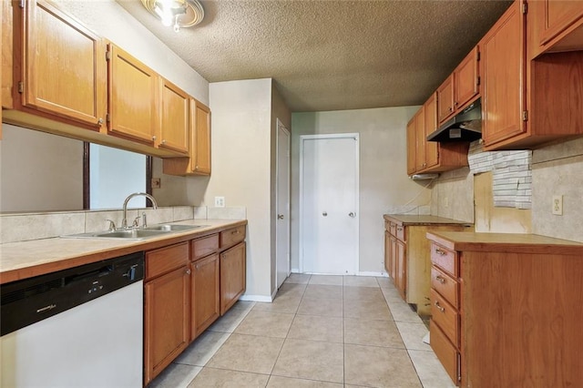 kitchen featuring dishwasher, sink, light tile patterned floors, a textured ceiling, and tasteful backsplash