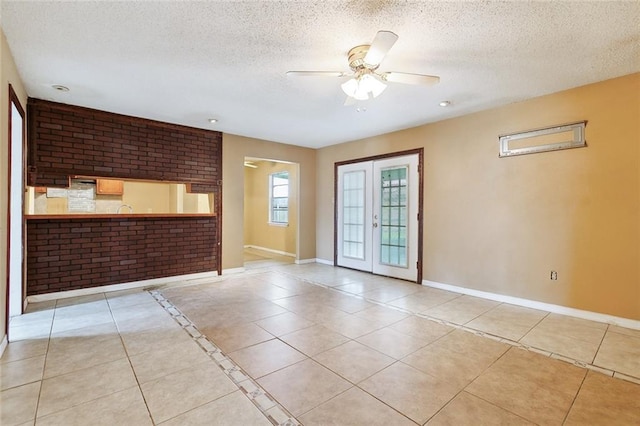 tiled spare room with french doors, a textured ceiling, and ceiling fan