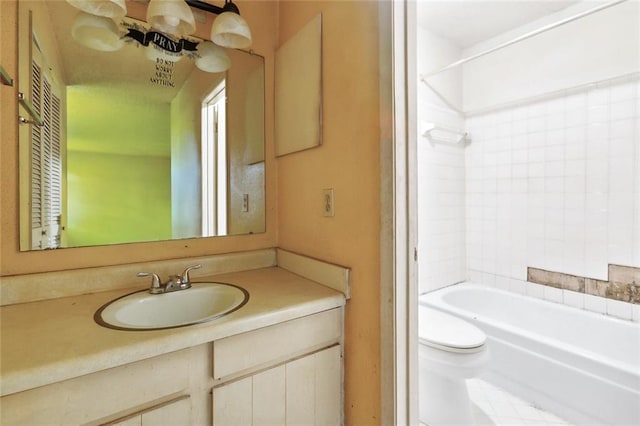 full bathroom with tiled shower / bath, vanity, and toilet