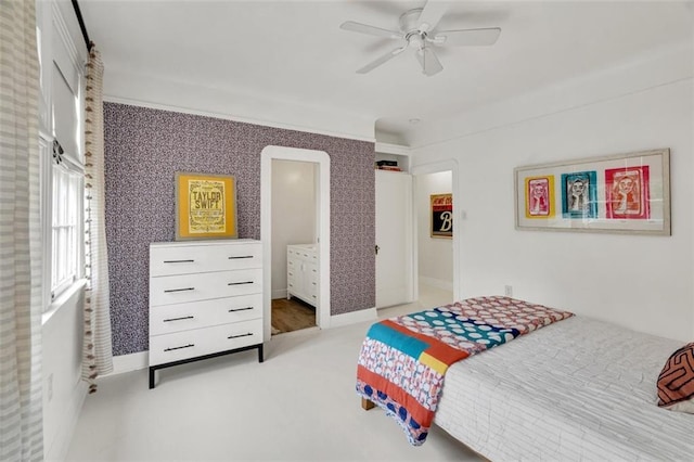 bedroom featuring ensuite bath, light carpet, and ceiling fan