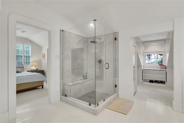 bathroom with vaulted ceiling, a healthy amount of sunlight, and a shower with shower door