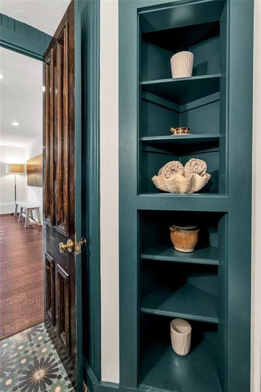 hallway featuring built in features and dark hardwood / wood-style floors