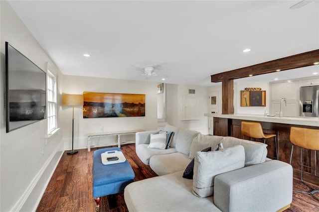 living room featuring hardwood / wood-style floors, sink, and ceiling fan