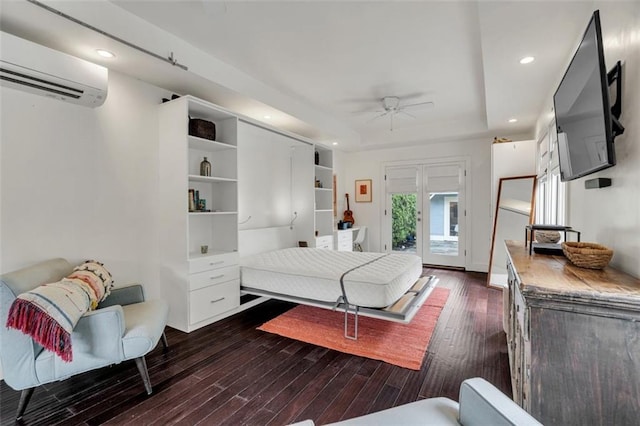 bedroom featuring ceiling fan, a wall unit AC, access to outside, and dark hardwood / wood-style flooring