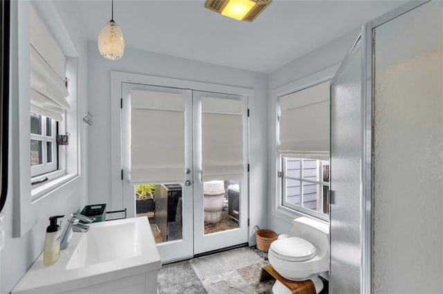 bathroom featuring french doors, toilet, and vanity