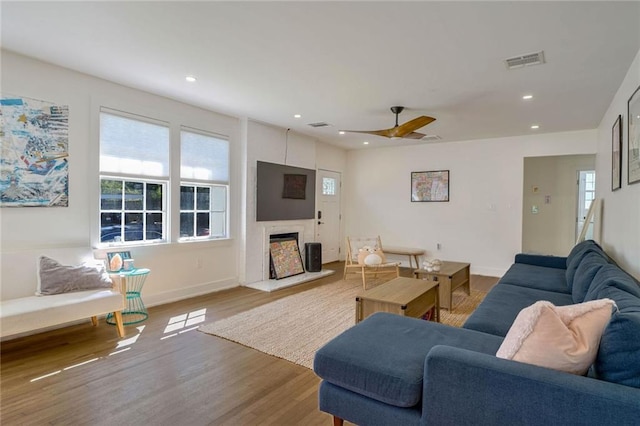 living room with light wood-type flooring and ceiling fan