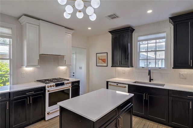 kitchen with custom exhaust hood, white cabinetry, light wood-type flooring, sink, and white appliances