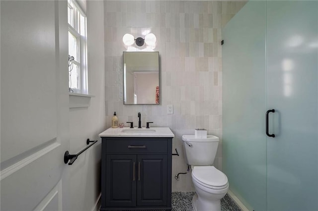 bathroom with walk in shower, tile walls, toilet, vanity, and tile patterned flooring