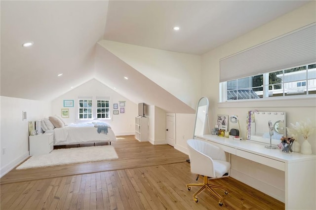 bedroom featuring built in desk, vaulted ceiling, and light wood-type flooring