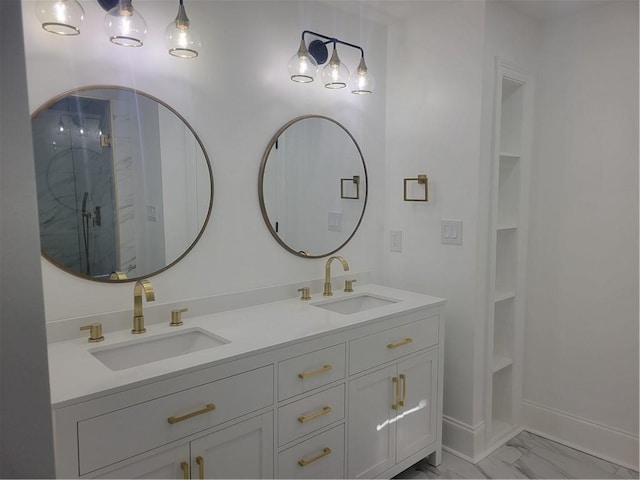 bathroom with a shower with door, vanity, and built in shelves