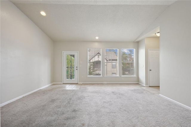 spare room with light colored carpet and a textured ceiling