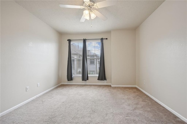 carpeted empty room with ceiling fan and a textured ceiling