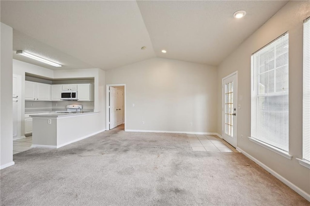 unfurnished living room featuring light colored carpet and vaulted ceiling